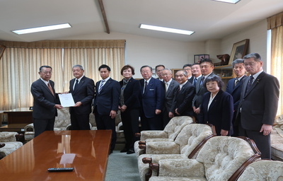 写真：中間報告書を議長に提出する様子