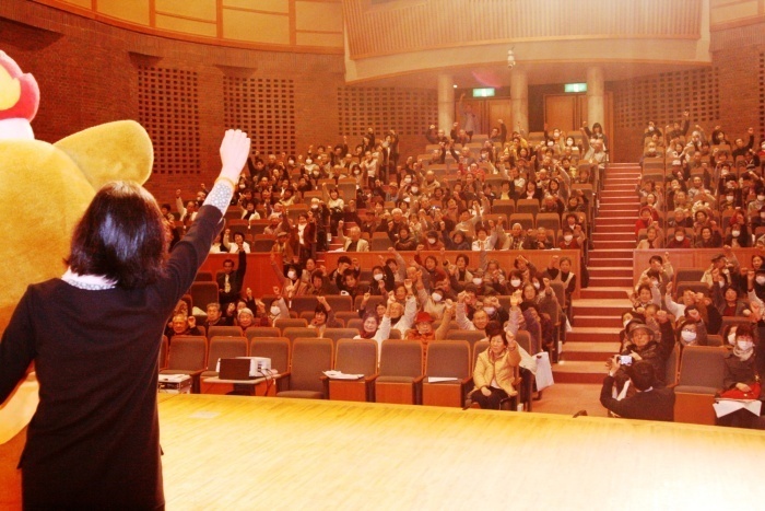 写真：1万人目が「認知症ど～もないちゃ！」とガッツポーズをする様子