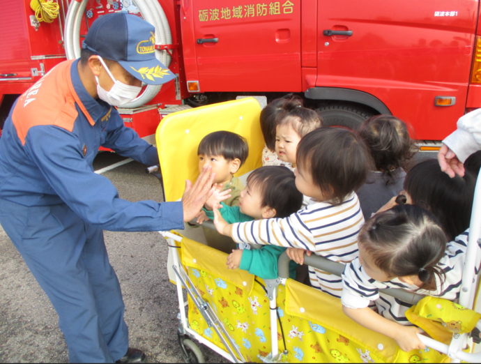 写真：消防士さんとハイタッチ